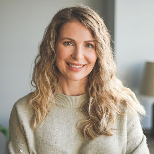 mature woman in soft green sweater smiling