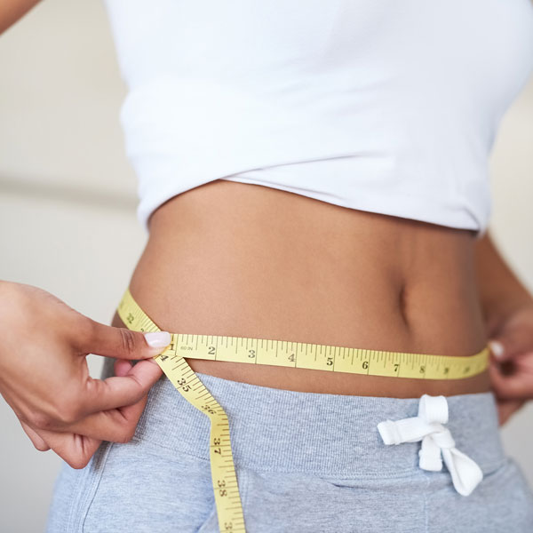 woman measuring waist size