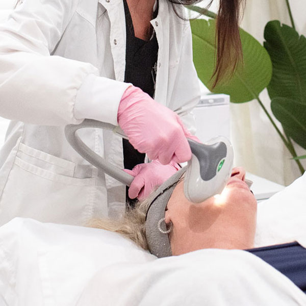 Laser facial being administered to client